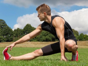 man-in-black-stretching-on-grass